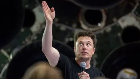 Getty Images Elon Musk speaks near a Falcon 9 rocket
