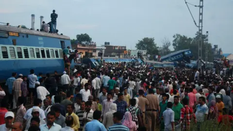 AFP Residents gather next to carriages after an express train derailed in the Indian state of Uttar Pradesh on August 19, 2017