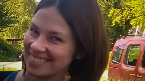 Family photo Tetiana Martynova smiling with a forest in the background