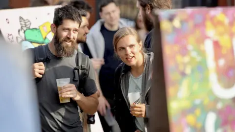 Plaster Communications A couple study a street art canvas as the Upfest street art festival begins in Bristol