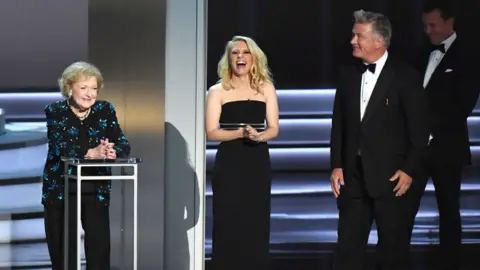 Getty Images Betty White entertains, Kate McKinnon, and Alec Baldwin onstage at the Emmy Awards in 2018.