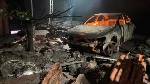 Macbeth set installation with burning car
