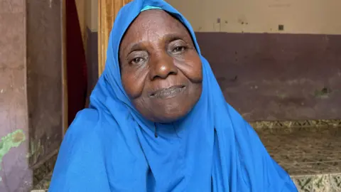 Gift Ufuoma/BBC A woman in a blue headscarf looking at the camera