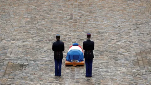 Christian Hartmann / Reuters French Republican guards stand in front of the flag-draped coffin of late Gendarmerie officer Colonel Arnaud Beltrame