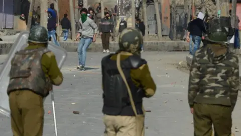 Getty Images Kashmiri demonstrators throw rocks at Indian police as they clash during a strike in downtown Srinagar on March 4,2013.