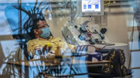 EPA A plasma donor (C) is seen at the newly inaugurated plasma bank of the Institute of Liver and Biliary Sciences (ILBS) donating plasma for the treatment of patients suffering from the COVID-19 coronavirus, in New Delhi on July 2, 2020.