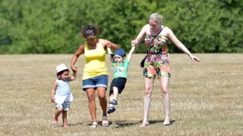 PA Two women and two children in a park on a sunny day.