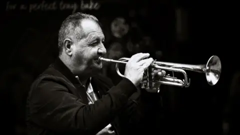 Cameron Pearce Man plays trumpet