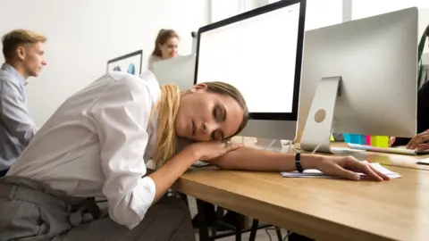 Getty Images Woman asleep on a desk