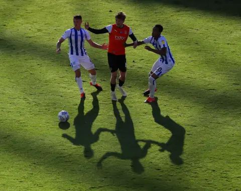 Mike Egerton / PA Media Huddersfield players Jonathan Hogg and Chris Willock battling for the ball