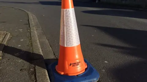 Traffic cone over a drain cover