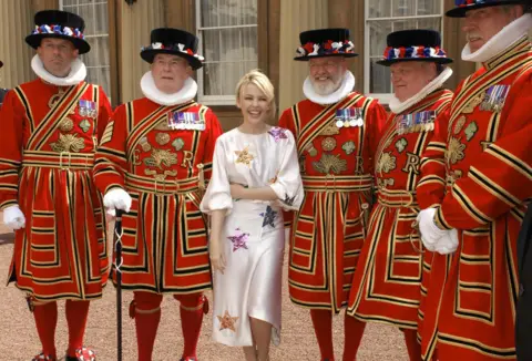 Getty Images Australian pop singer Kylie Minogue (C) poses for photographs with Beefeaters after receiving her Order of the British Empire (OBE) from the Prince of Wales for services to music, at Buckingham Palace, in London, on 3 July 2008.