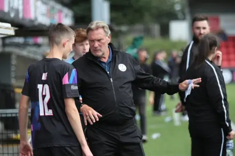 PAcemaker Glenn Hoddle speaks to a young player at the BT Hope United match at Seaview in Belfast