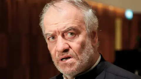 Getty Images Conductor Valery Gergiev looks on after a concert by the Mariinsky Theatre Symphony Orchestra marking the 50th birthday of violinist Vadim Repin at the Zaryadye Concert Hall on 5 September 2021