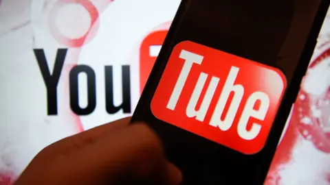 Getty Images The YouTube logo split between a wall and a phone screen