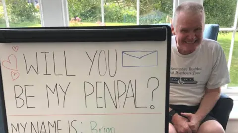 Cleeve Lodge Brian with a sign asking for a penpal who loves Star Wars, Star Trek and Scooby Doo