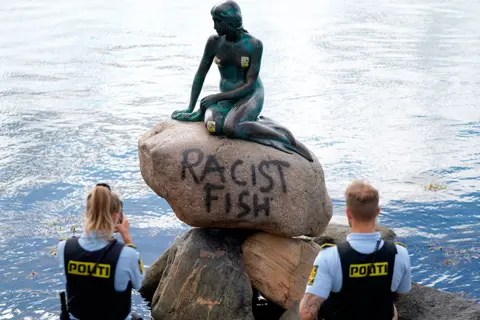 Mads Claus Rasmussen / AFP Police take a photo of a statue of a mermaid with the words Racist Fish daubed on it