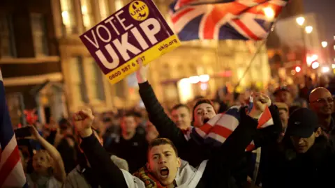 Getty Images Demonstrators punch the air and march holding flags and Vote UKIP placards