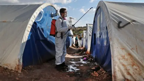  AFP/Getty Images A member of the Syrian Violet NGO disinfects tents at a camp for displaced people in Kafr Jalis village, north of Idlib city, on March 21, 2020