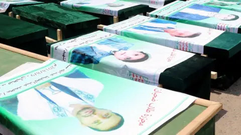 AFP Mourners in Saada city stand next to the coffins of Yemenis killed in a Saudi-led coalition air strike in Dahyan (13 August 2018)