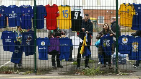 PA Volunteers hang up shirt tributes left for the victims