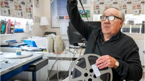 Noel Cronin Noel Cronin with a reel of film