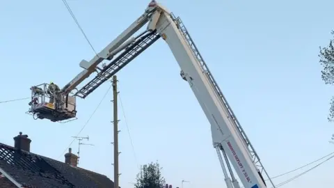 Essex Fire and Rescue Service Firefighters inspecting roof of property