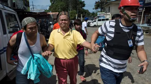 AFP Evacuated residents arrive at a checkpoint in Marawi City on the southern island of Mindanao