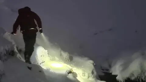 Glossop Mountain Rescue Rescuer walks through snow