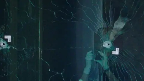 Reuters Bullet holes seen in a plate glass window at a bank in Louisville this month