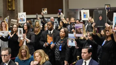 Getty Images Families of victims holding up photos of their loved ones
