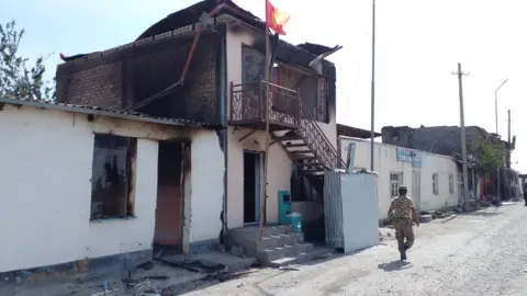 BBC An official walks along a deserted street following clashes near the Kyrgyzstan-Tajikistan border