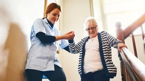 Getty Images A carer with a woman