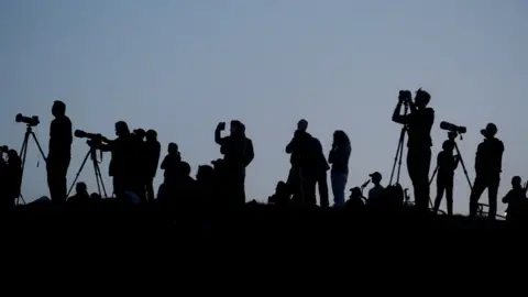 Reuters Silhouetted media members and people documenting the full moon, also known as the Supermoon or Flower Moon, over Primrose Hill, are seen in London, Britain