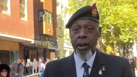 Kate Bradbrook/BBC Man with grey beard wearing beret and RBL tie