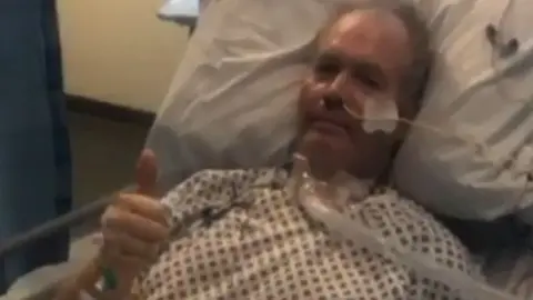 David McWilliams Robert in an ICU bed with his thumbs up