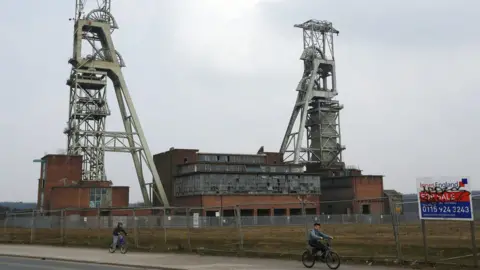 Reuters Boys cycle past the closed Clipstone Colliery in Clipstone near Mansfield