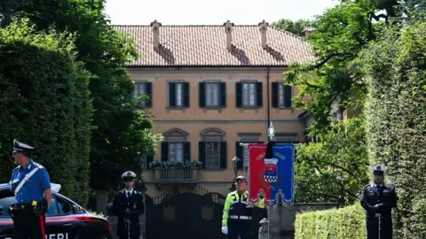 GABRIEL BOUYS/AFP Municipal police stand guard outside Villa San Martino, the residence of Italian businessman and former prime minister Silvio Berlusconi, following his death