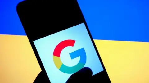 Getty Images The Google logo on a smartphone in front of the Ukraine flag