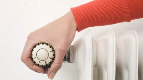 Getty/Westend61 Female hand on thermostat