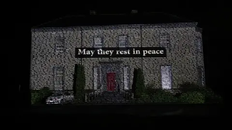 Niall Carson/PA Media The names of children who died in Bessborough Mother and Baby Home in Cork projected onto Sean Ross Abbey