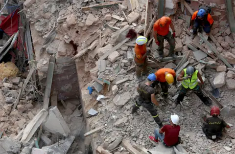 Aziz Taher / Reuters Rescuers search the rubble of a collapsed building