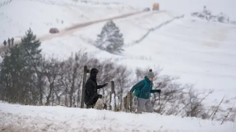 PA Media Man and woman rambling in snow