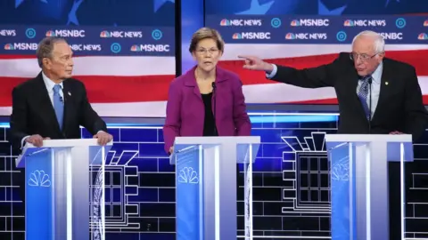 Getty Images Mike Bloomberg, left, Elizabeth Warren, middle, and Bernie Sanders, right, on the debate stage.
