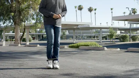 Wrap Technologies A promotional shot showing how the BolaWrap can constrict a person's legs with its cord