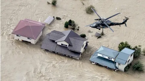 Reuters Defence force helicopter flying over residential areas flooded by the Chikuma river following Typhoon Hagibis in Nagano, central Japan, October 13, 2019