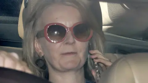 Getty Images Liz Truss speaks on her phone as she is driven into the Houses of Parliament in central London on September 25, 2019