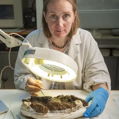 MOLA Conservator Liz Barham working on the burial