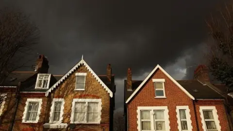 Getty Images Dark clouds over houses