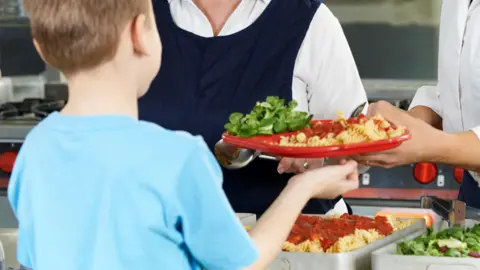 Alamy A boy is served food at a canteen in Italy